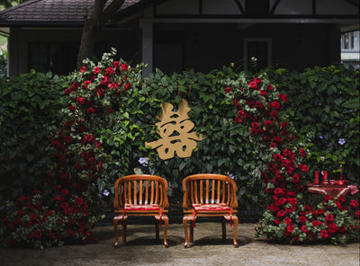 Chinese wedding tea ceremony backdrop with red roses, double happiness symbol and two wooden chairs