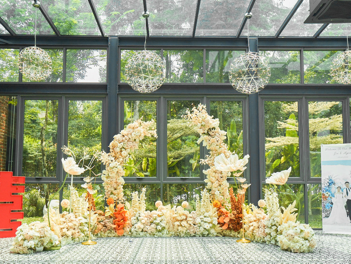 Edenmill wedding backdrop with cream and white florals and warm orange accents