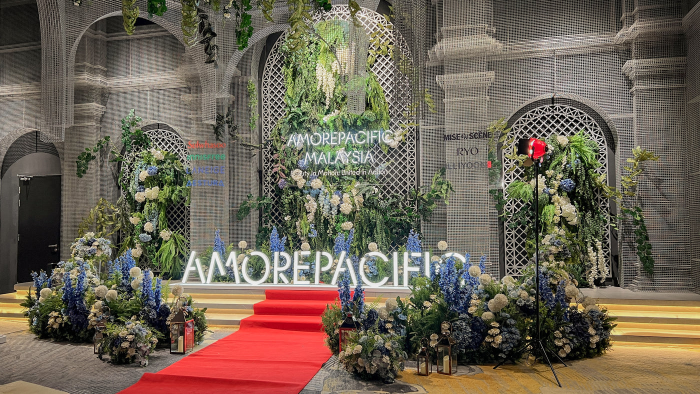 Amorepacific Malaysia annual dinner stage with floral backdrop, branded signage and red carpet