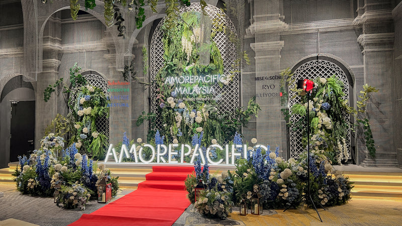 Amorepacific Malaysia annual dinner stage with floral backdrop, branded signage and red carpet