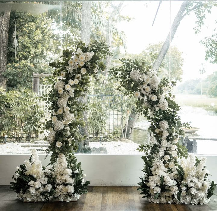 Outdoor wedding ceremony floral arch with white and green flowers