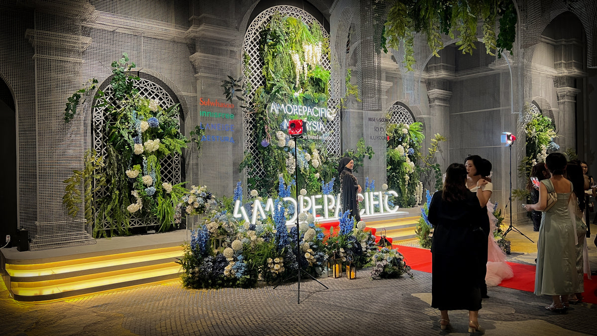 Amorepacific Malaysia annual dinner stage with floral backdrop, branded signage and red carpet